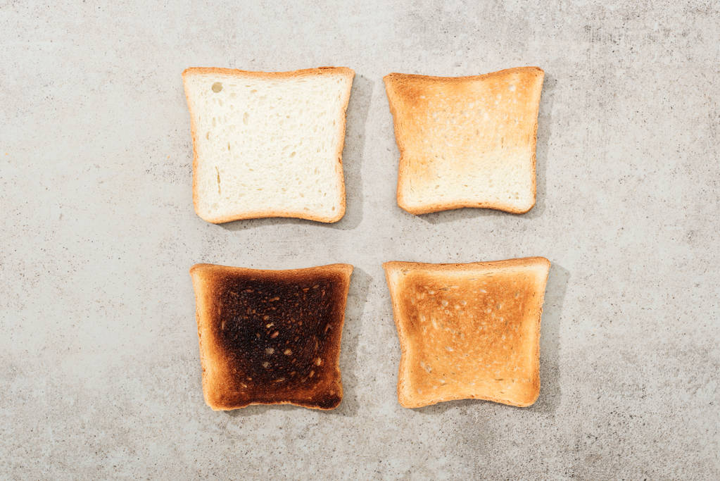 Верхний вид хлебных тостов на серой текстурной поверхности
 - Фото, изображение