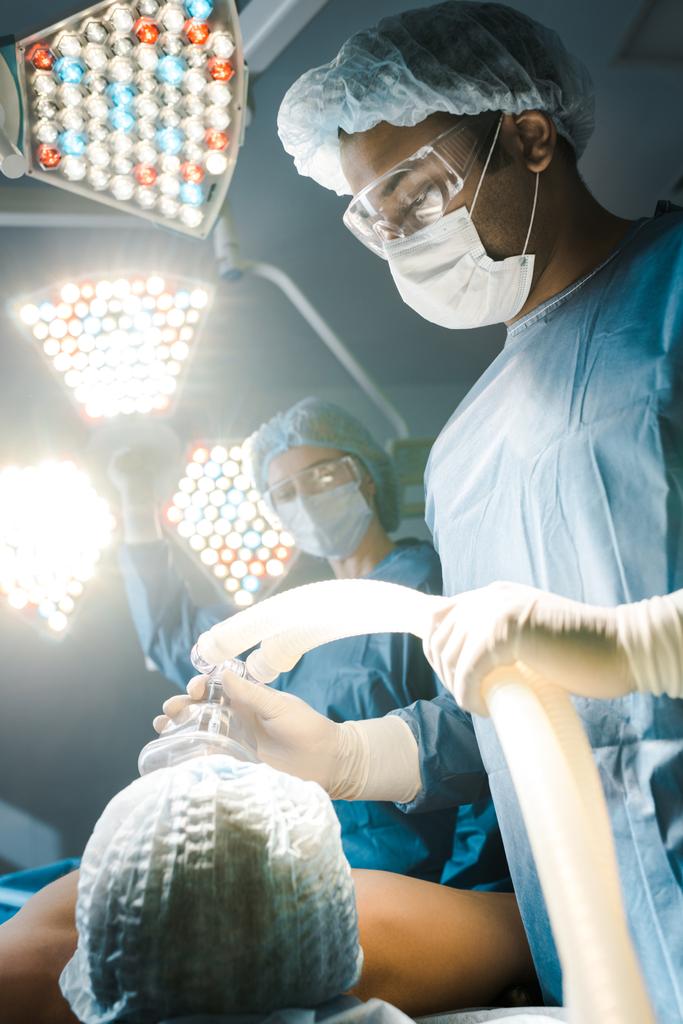 selektivní zaměření chirurga v uniformě a brýle na pacienta  - Fotografie, Obrázek