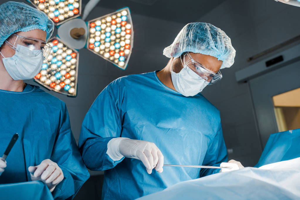 infirmière et chirurgienne en uniforme et masques médicaux en opération
  - Photo, image