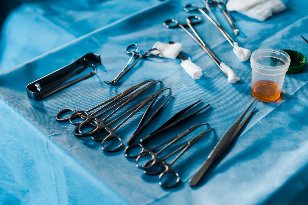 attrezzature metalliche per interventi chirurgici su panno blu in sala operatoria
  - Foto, immagini