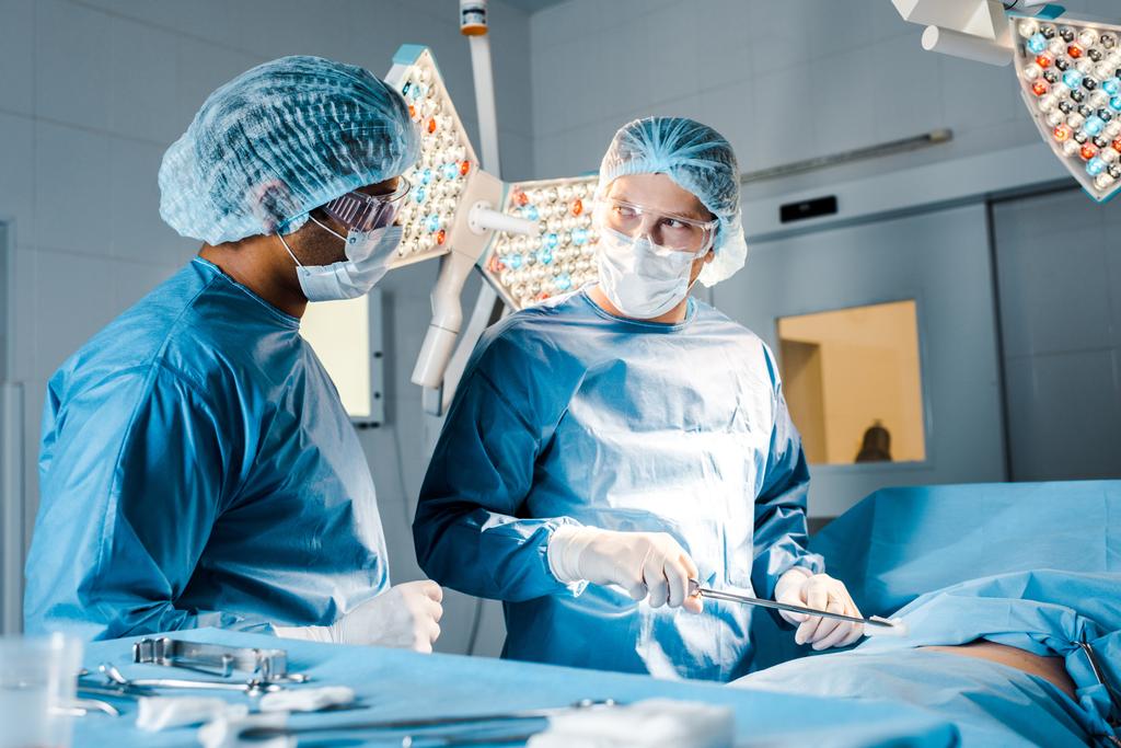 ápoló és sebész egyenruhát és orvosi maszkokat csinál művelet  - Fotó, kép