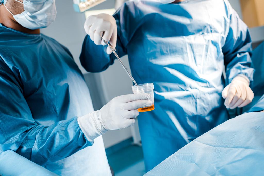 cropped view of surgeon putting tampon to iodine in operating room - Photo, Image