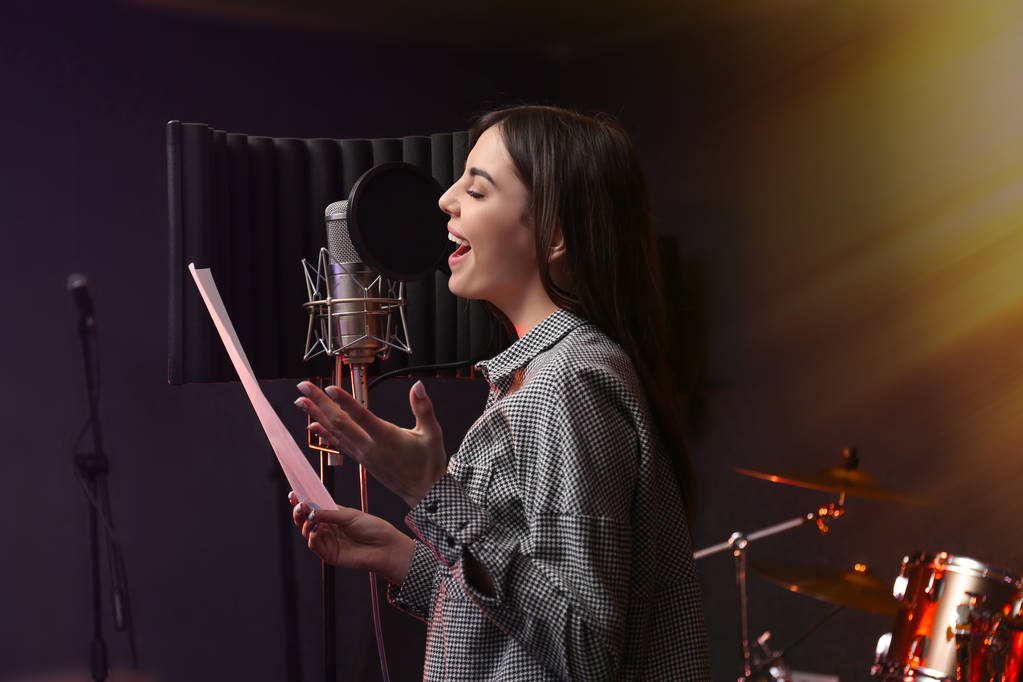Genç şarkıcı şarkı stüdyoda kayıt mikrofon ile - Fotoğraf, Görsel