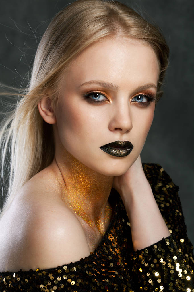 Fashion portrait of young caucasian model with golden sparkles on her neck. - Photo, Image