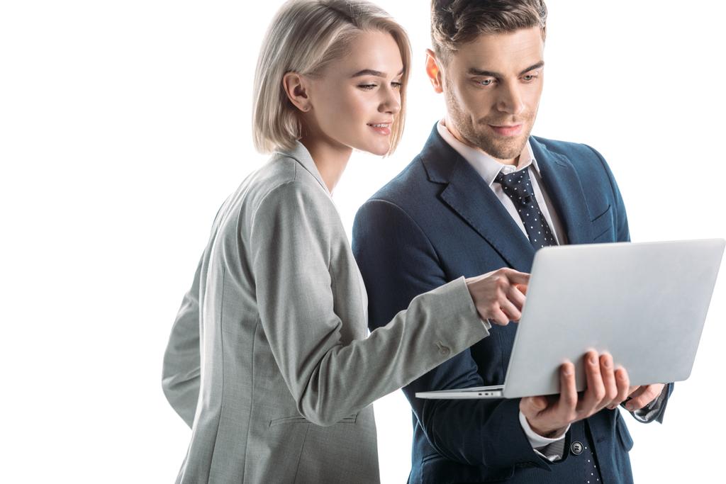 веселая деловая женщина, указывающая пальцем на экран ноутбука рядом с красивым бизнесменом, изолированным на белом
 - Фото, изображение