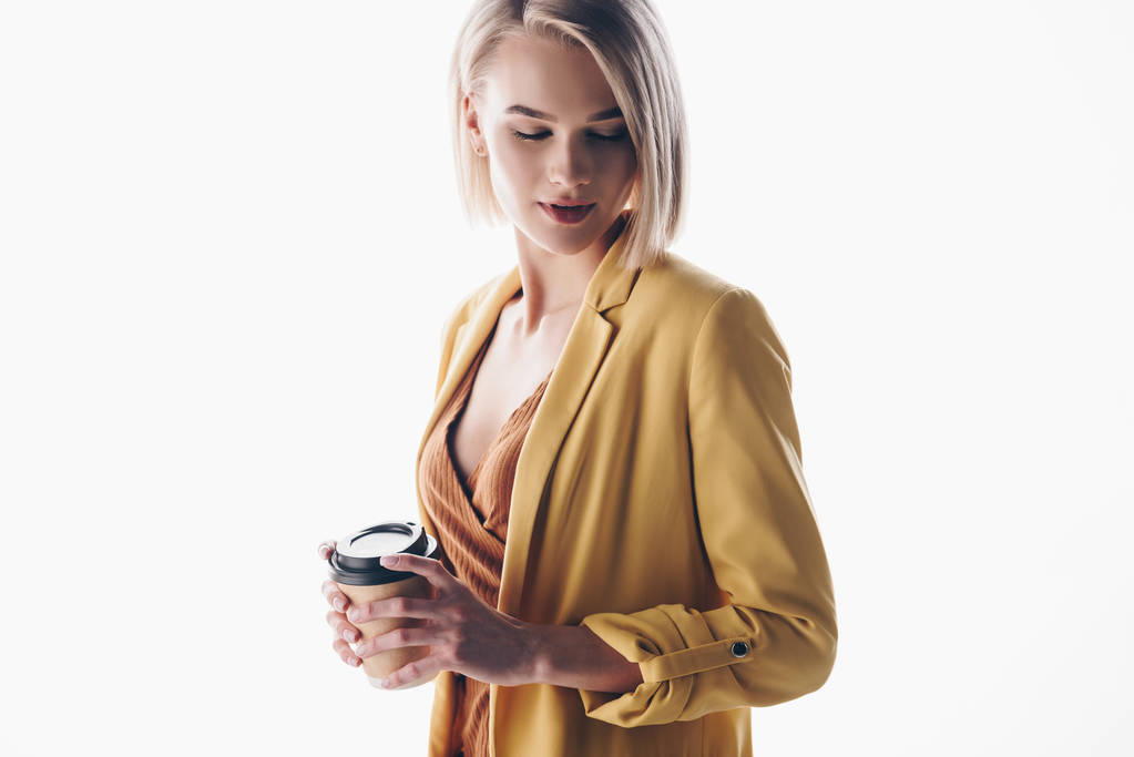 krásná žena s blond vlasy přidržující papírový pohár na šedé - Fotografie, Obrázek