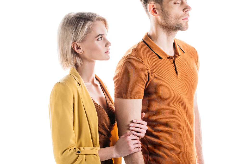 привлекательная, серьезная молодая женщина держит за руку уверенного мужчину изолированного на белом
 - Фото, изображение