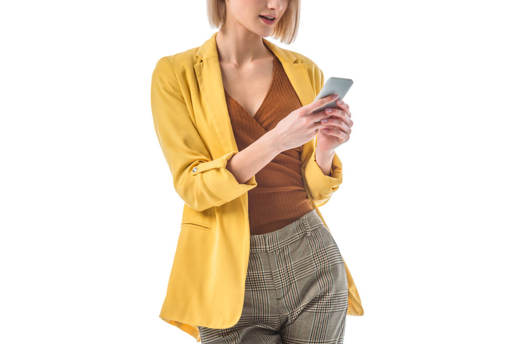 visão parcial da mulher na moda usando smartphone isolado no branco
 - Foto, Imagem