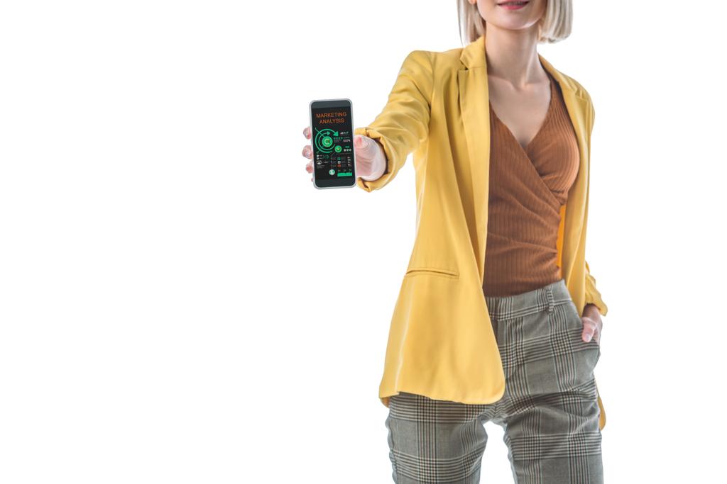 partial view of woman with hand in pocket holding smartphone with marketing analysis app on screen isolated on white - Photo, Image