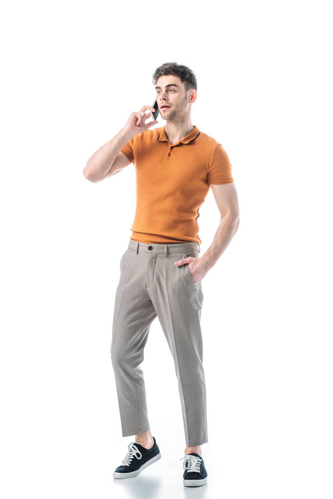 beau jeune homme avec la main dans la poche parler sur smartphone isolé sur blanc
 - Photo, image