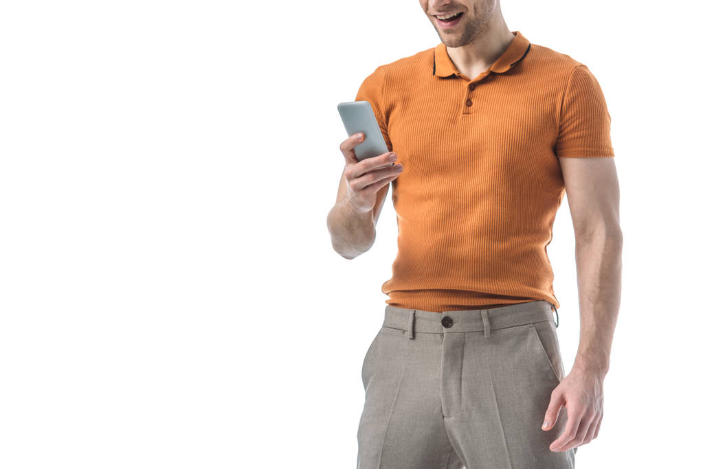 частичный вид улыбающегося модного человека с помощью смартфона, изолированного на белом
 - Фото, изображение