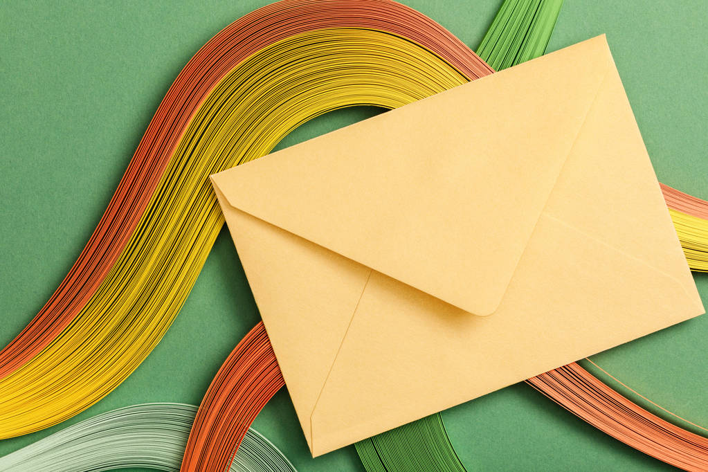 вид сверху разноцветных абстрактных линий на зеленом фоне с желтым конвертом
 - Фото, изображение