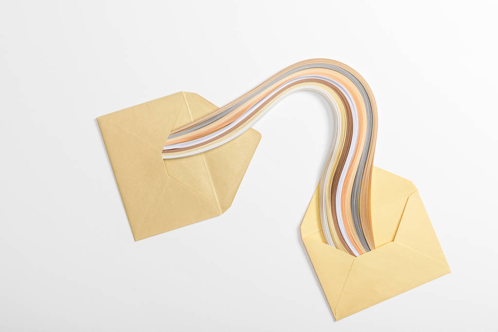 вид сверху на желтые конверты с разноцветной радугой на сером фоне
 - Фото, изображение