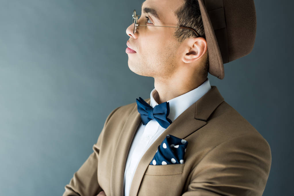 sivunäkymä tyylikäs sekoitettu rodun mies puku ja aurinkolasit poseeraa harmaa kopioi tilaa
 - Valokuva, kuva