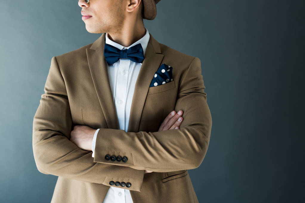 corte vista de elegante mestiço homem de raça em terno com braços cruzados isolado em cinza
 - Foto, Imagem