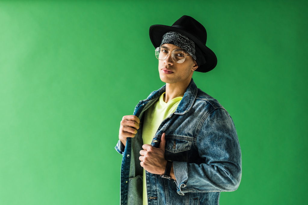 stylish mixed race man posing and looking at camera on green screen with copy space - Photo, Image