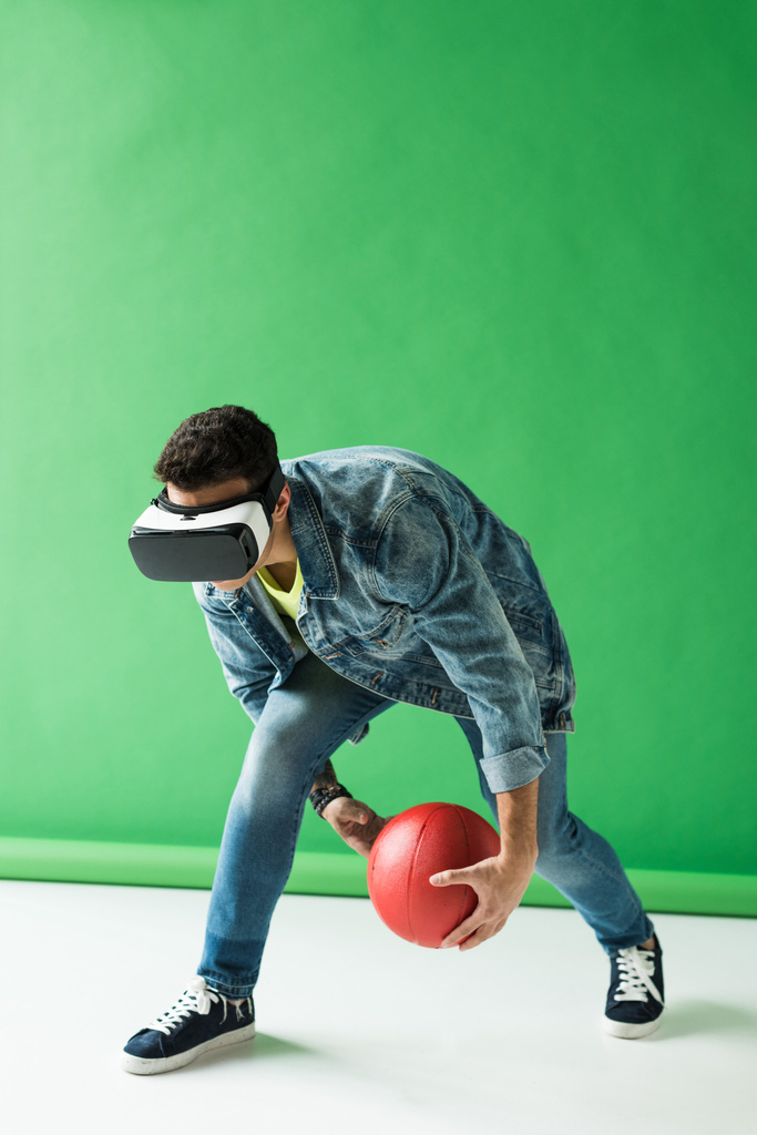 mieszany człowiek rasy w wirtualnej rzeczywistości słuchawki gospodarstwa koszykówki na zielono z kopią przestrzeni - Zdjęcie, obraz