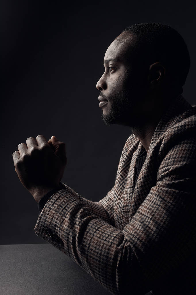 Dark key portrait of serious man in profile, weared in plaid suit jacket. Studio shot - Photo, Image