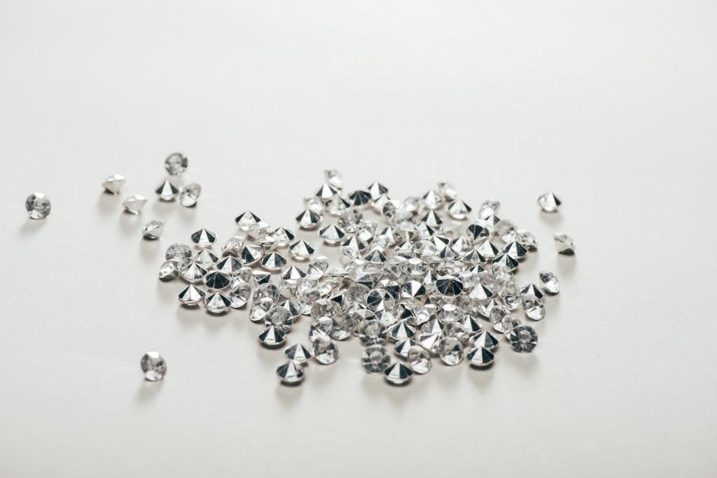 διαφανή καθαρή μικρά διαμάντια διάσπαρτα σε λευκό φόντο - Φωτογραφία, εικόνα
