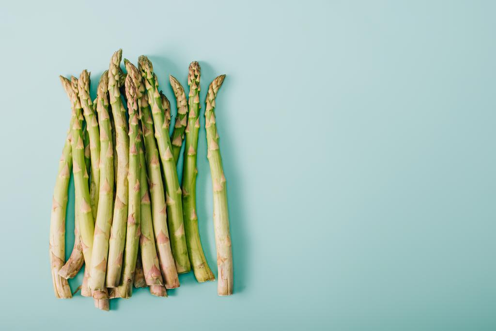 top view of green raw asparagus on blue background with copy space - Photo, Image
