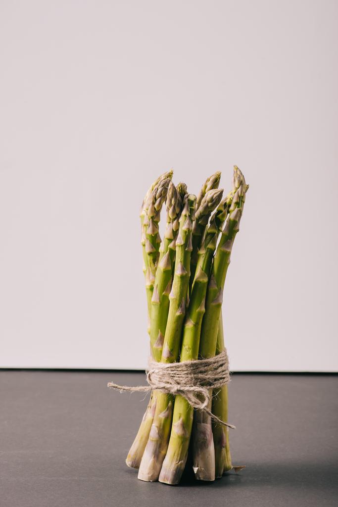 bouquet d'asperges vertes attachées à la corde sur la surface grise
 - Photo, image