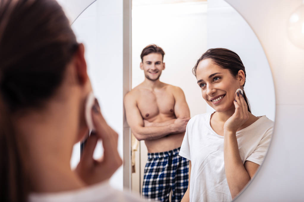 Sexy marido com bons abdominais assistindo sua esposa remover maquiagem
 - Foto, Imagem