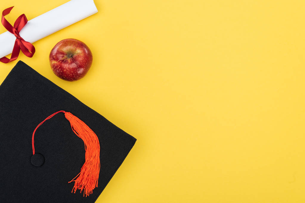 Widok z góry akademickich WPR, dyplom i czerwone jabłko na powierzchni żółty - Zdjęcie, obraz
