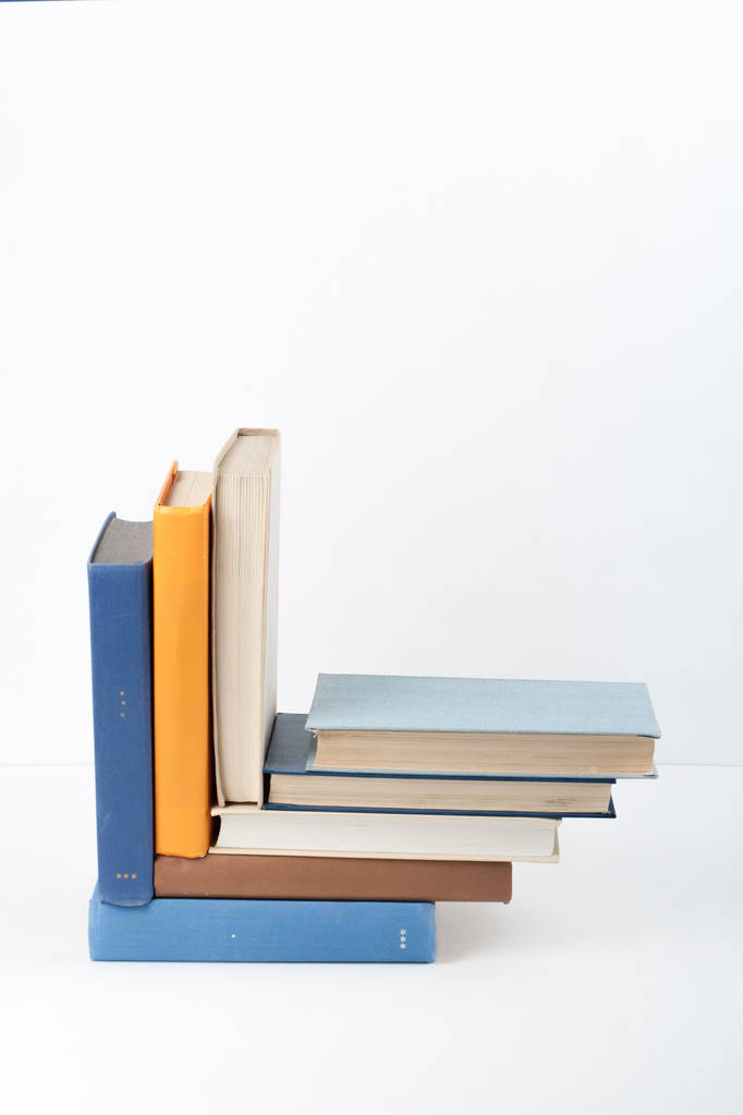 Avoin kirja, kova selkä värikkäitä kirjoja puinen pöytä, valkoinen tausta. Takaisin kouluun. Kopioi tilaa tekstille. Koulutuksen käsite - Valokuva, kuva