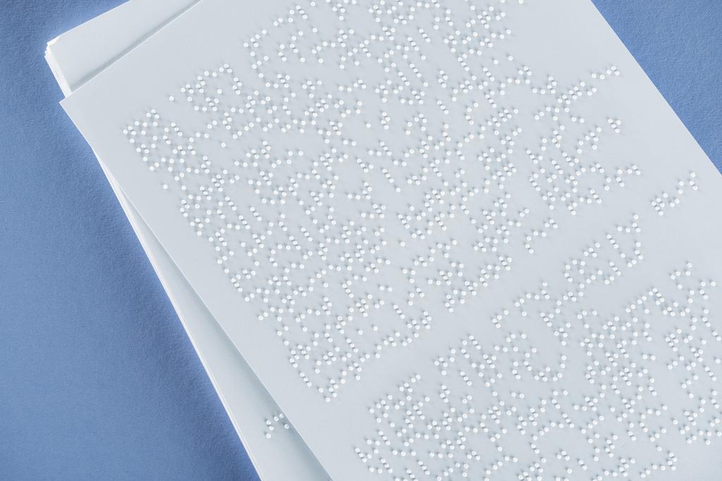 top view of braille text on white paper isolated on violet - Photo, Image