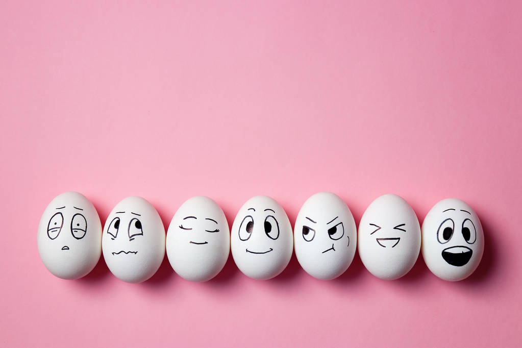 Huevos de Pascua divertidos con expresiones faciales. Huevos con diferentes caras sobre fondo rosa
.  - Foto, Imagen