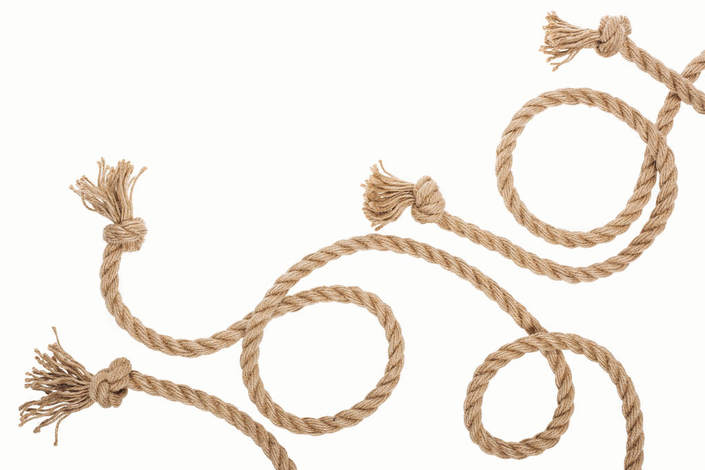 bruin jute en gekrulde kabels met knopen geïsoleerd op wit  - Foto, afbeelding