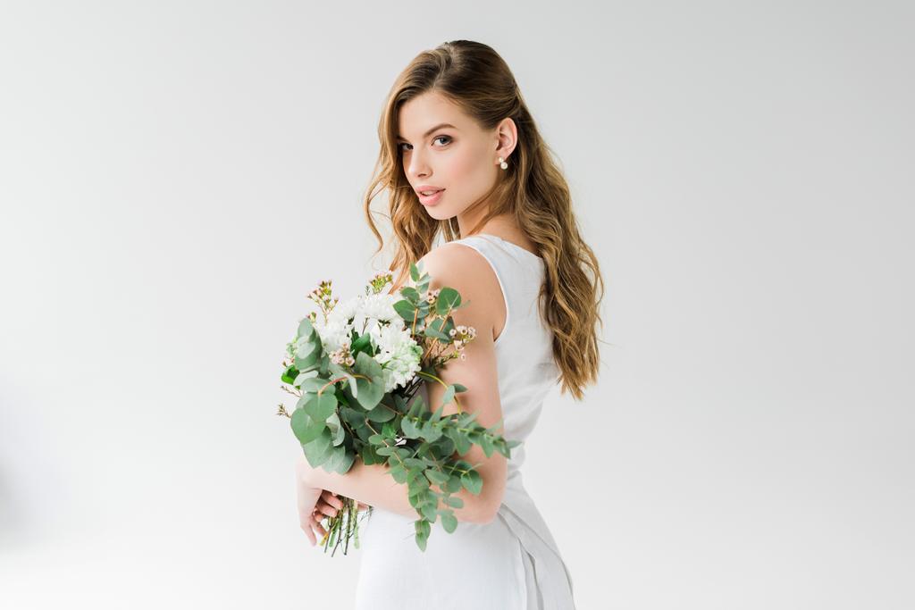 ελκυστικό κορίτσι σε λευκό κρατώντας λουλούδια σε λευκό - Φωτογραφία, εικόνα