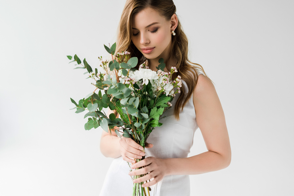 belle jeune femme en robe regardant des fleurs sur blanc
 - Photo, image