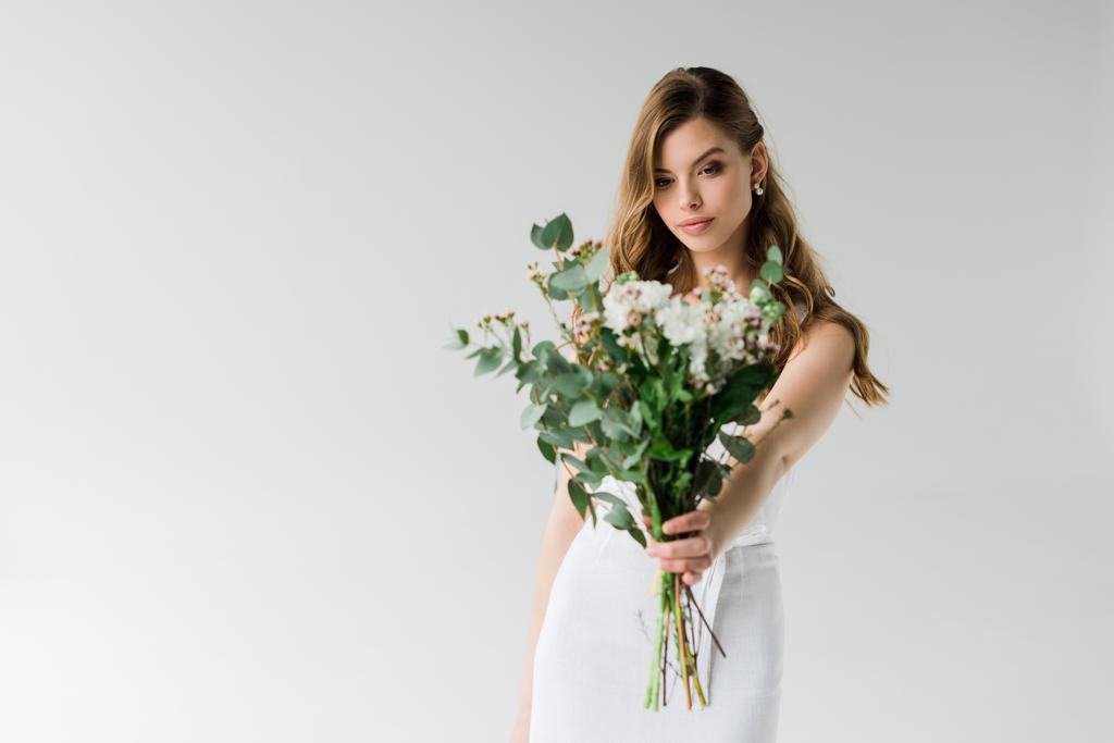 селективный фокус привлекательной девушки, держащей букет цветов на белом
 - Фото, изображение