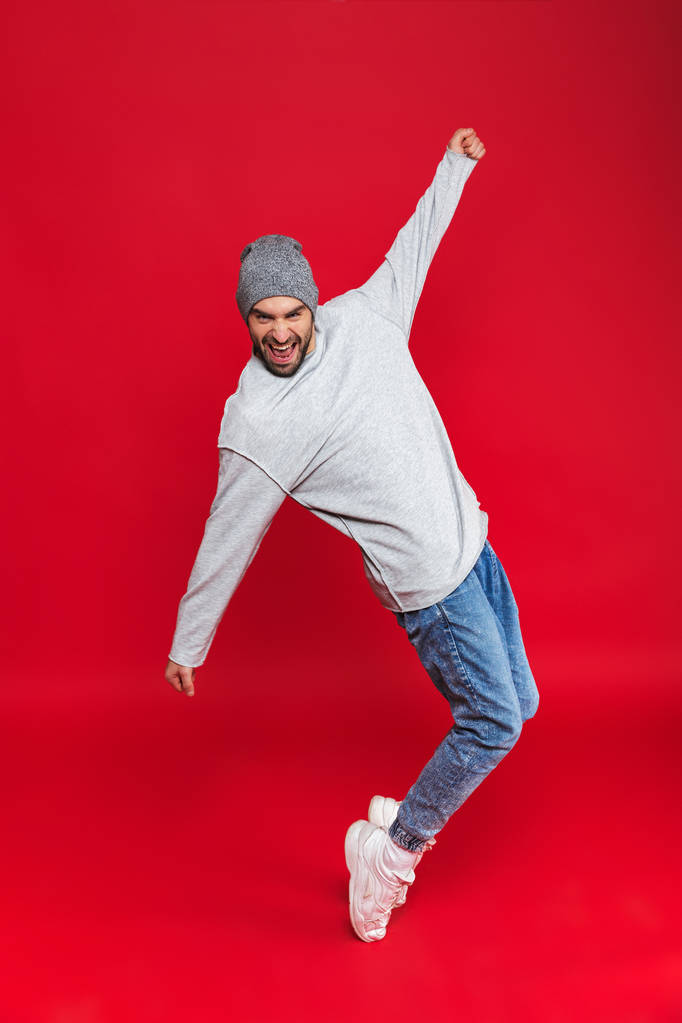 Полнометражное фото стильного мужчины, улыбающегося и прыгающего изолированного
 - Фото, изображение