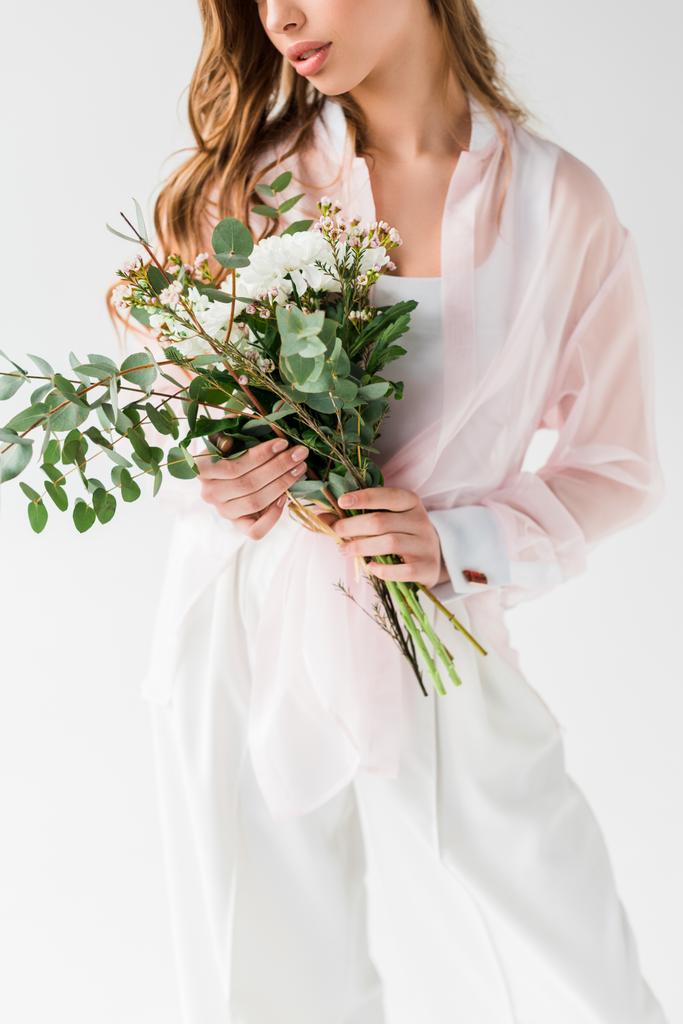 cropped view of girl holding flowers with green eucalyptus leaves on white  - Photo, Image