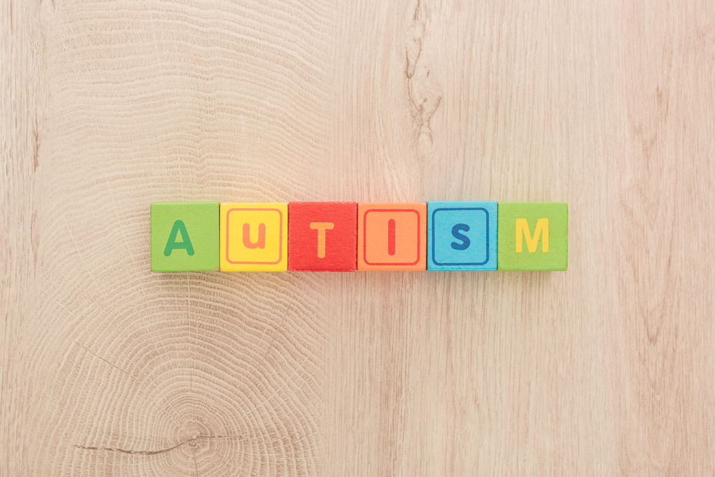 Widok z góry z autyzmem napis wykonany z kostki wielobarwny na drewnianym stole - Zdjęcie, obraz