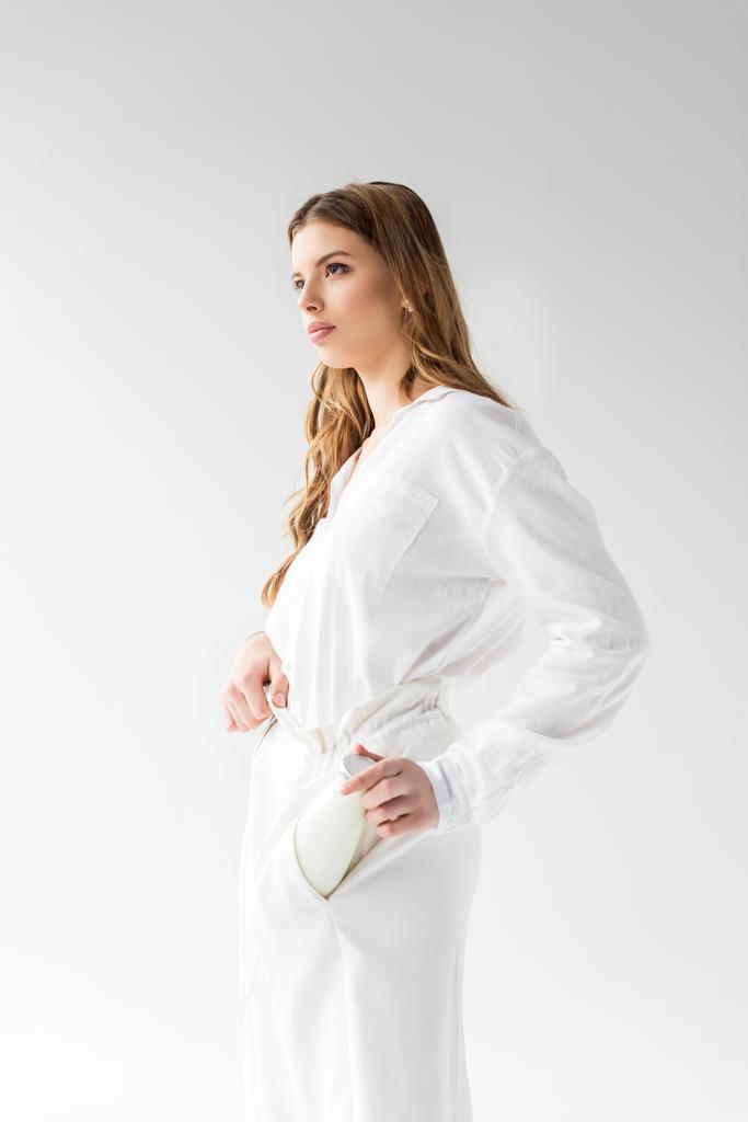 atractiva mujer poniendo botella de leche en el bolsillo en blanco
  - Foto, Imagen