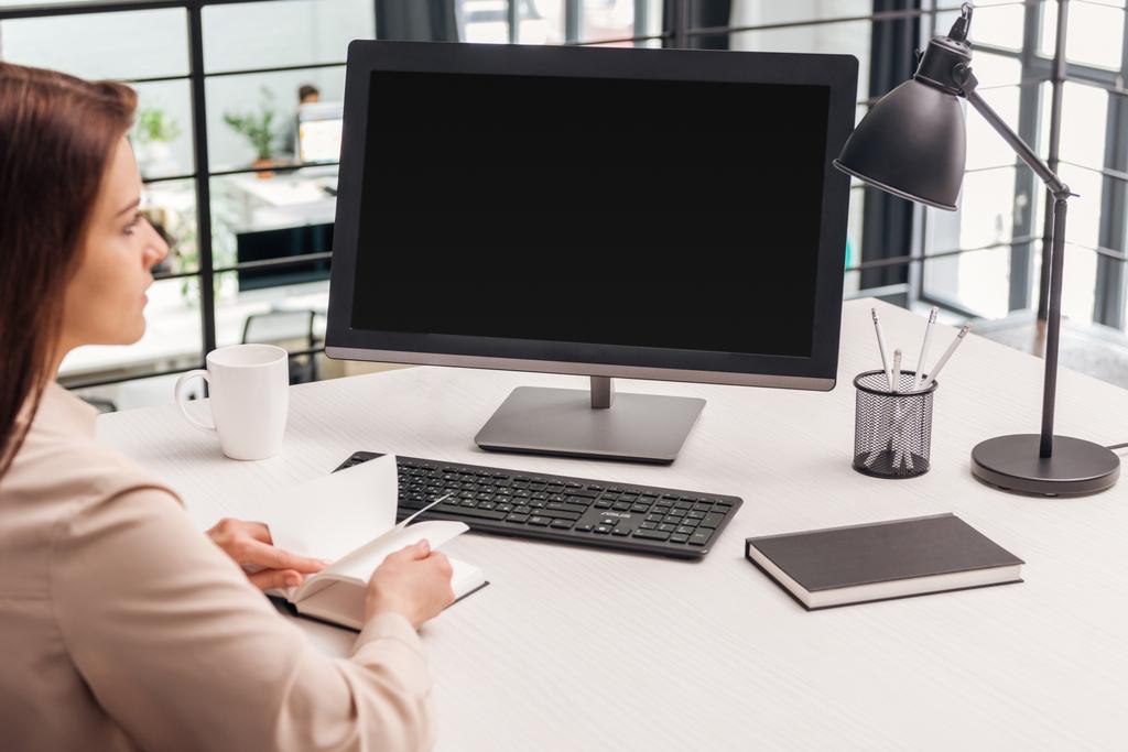 foyer sélectif de la femme assise avec ordinateur portable près de l'ordinateur au travail dans le bureau
 - Photo, image
