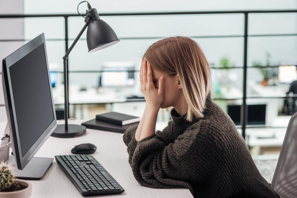 bouleversé fille assis sur le lieu de travail avec les mains sur le visage dans le bureau moderne
 - Photo, image
