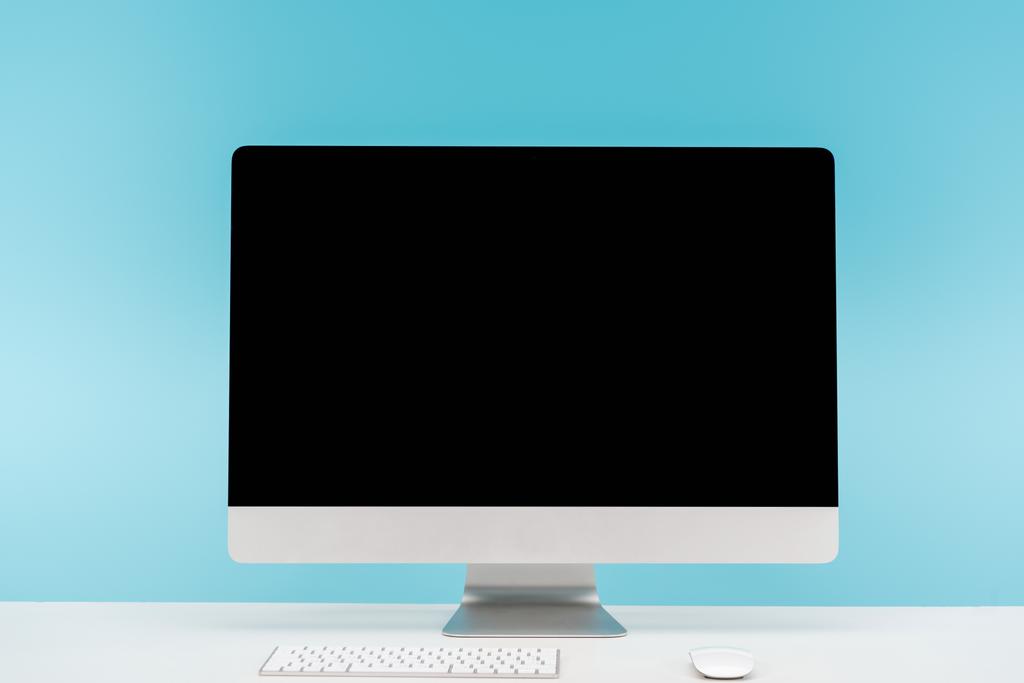 pracy z monitora, klawiatury i komputera mysz komputerowa na stół biały na niebieskim tle - Zdjęcie, obraz