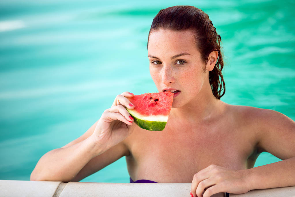 Svůdná žena v bazénu aktualizuje s kusem melounu - Fotografie, Obrázek