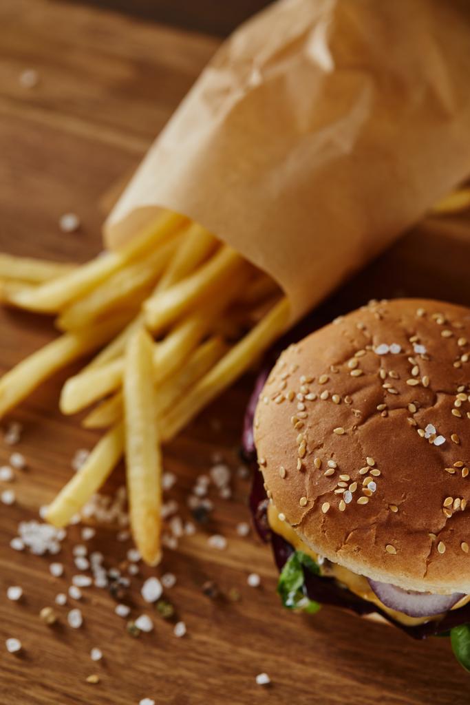 selektivní zaměření soli, hranolky a burgery na dřevěné povrchy  - Fotografie, Obrázek