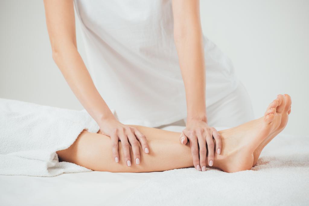 vista parcial de masajista haciendo masaje de pies a mujer adulta en spa
 - Foto, imagen