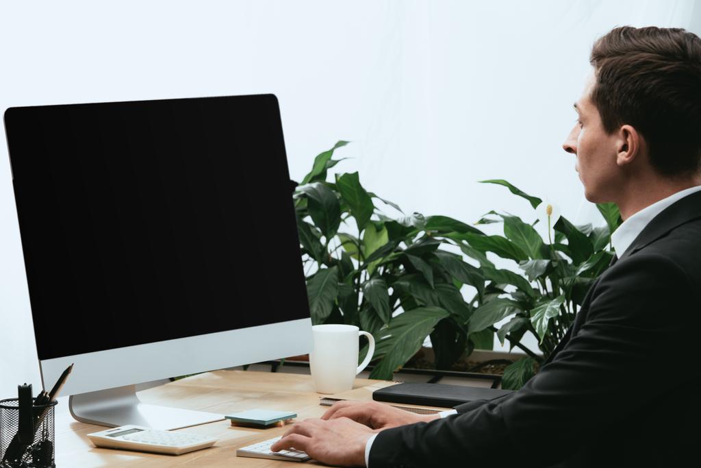 homem adulto de terno usando computador com tela em branco e espaço de cópia
  - Foto, Imagem