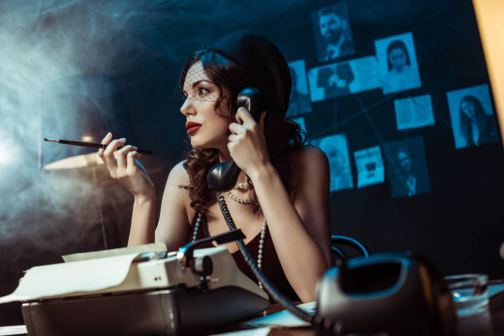 美しい女性は、暗いオフィスで電話で話すマウスピースを持つ - 写真・画像