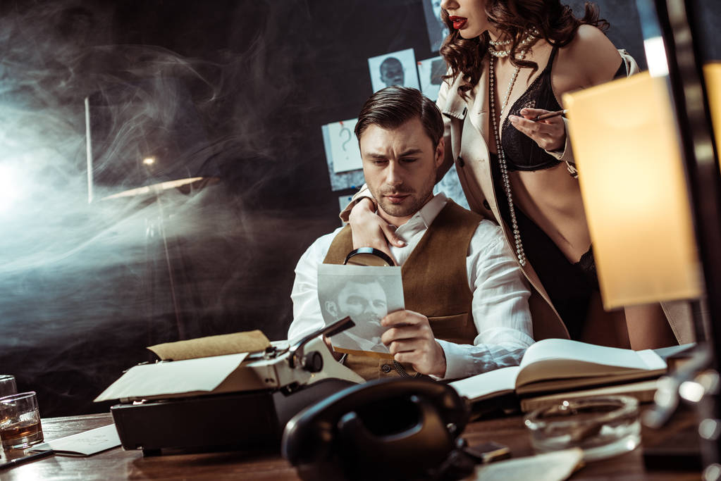 Обрізаний вид сексуальної жінки в нижній білизні і траншеї пальто спокушає детектива в офісі
 - Фото, зображення