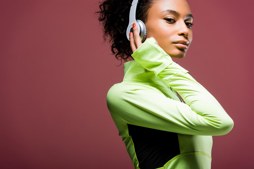 attractive african american sportswoman in headphones looking at camera isolated on brown with copy space - Photo, Image