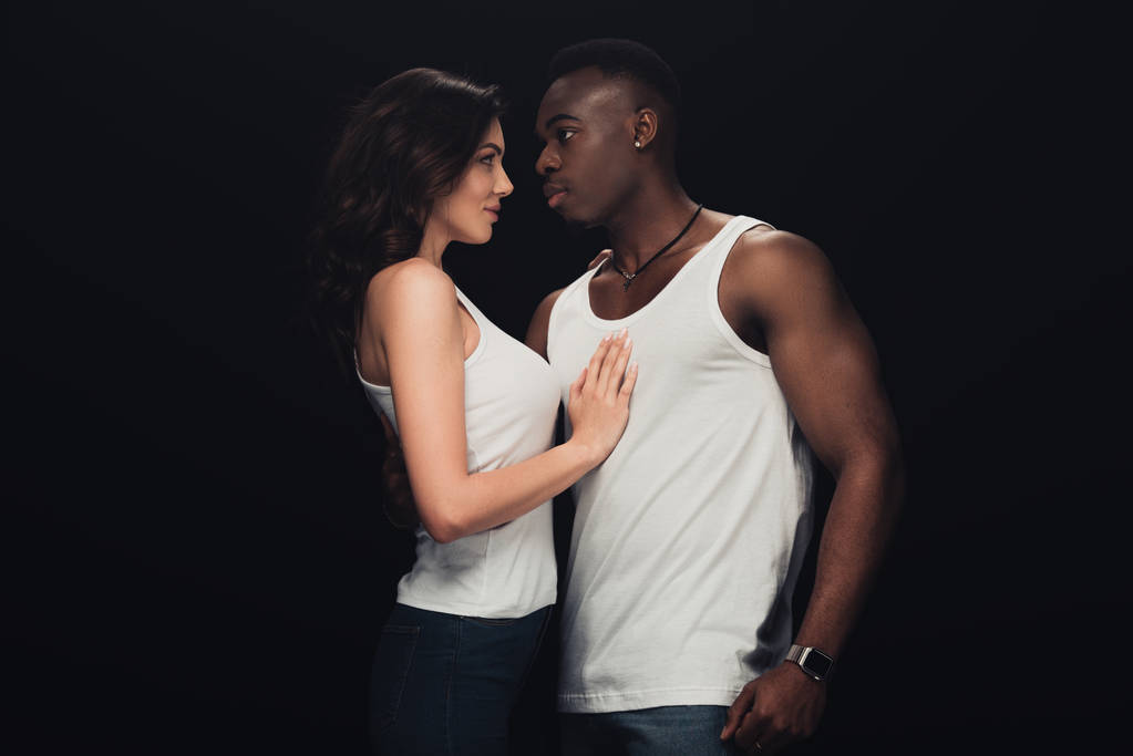 beautiful sensual interracial couple in white tank tops isolated on black - Photo, Image