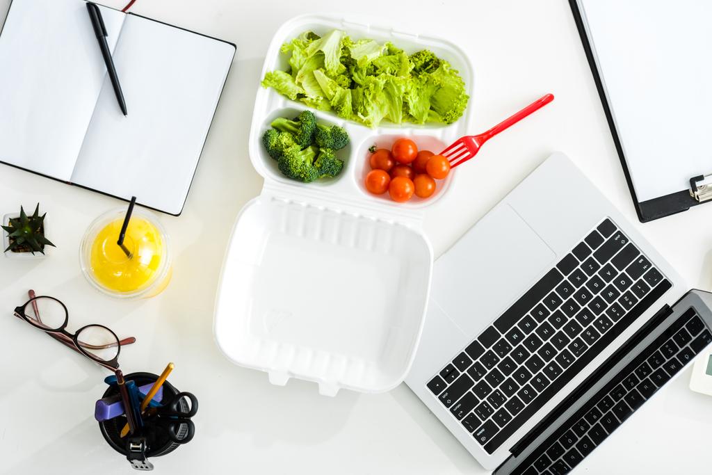 top view of tasty vegetables near laptop and notebook with copy space  - Photo, Image